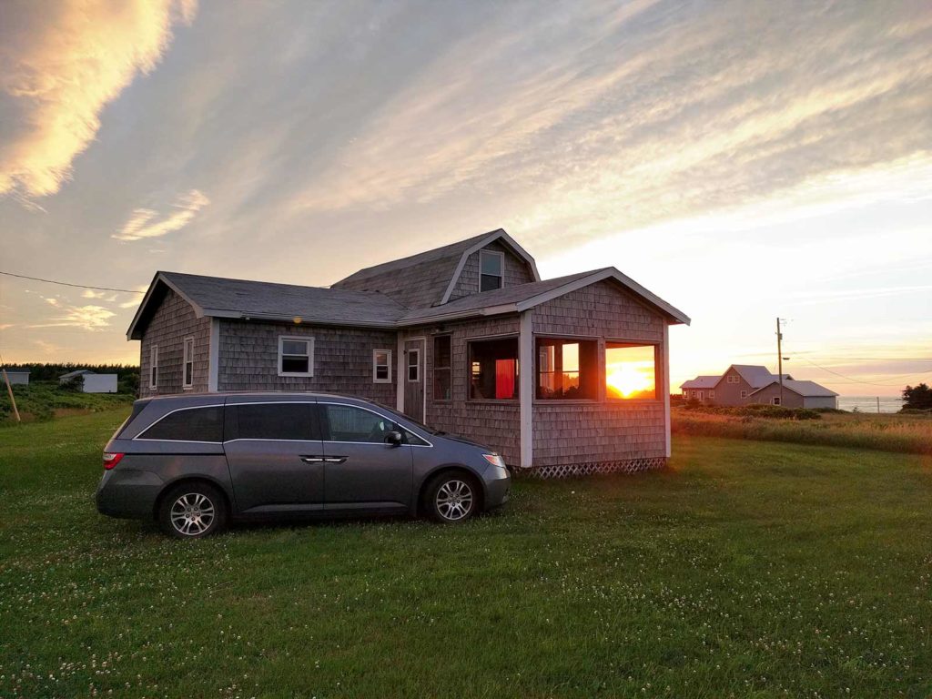 Grey 2013 Honda Odyssey minivan in front of cottage