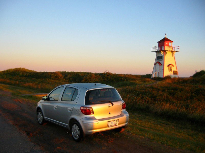 Silver 2004 Toyota Echo hatchback in sunset with lighthouse