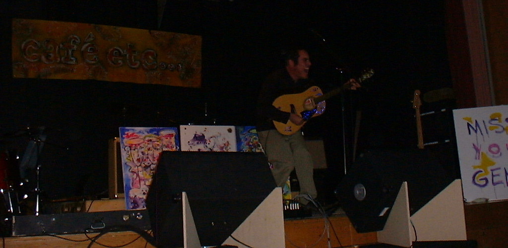 Mike Knott performing on state with an acoustic guitar